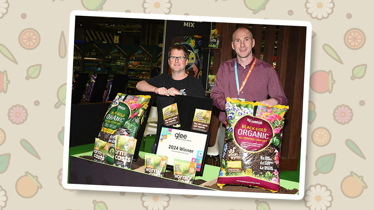 Two men holding an award and Gro Worm products at the Glee 2024 New Product Awards