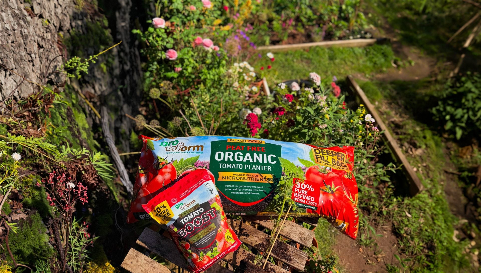 Gro Worm organic tomato planter and tomato boost in a flower garden